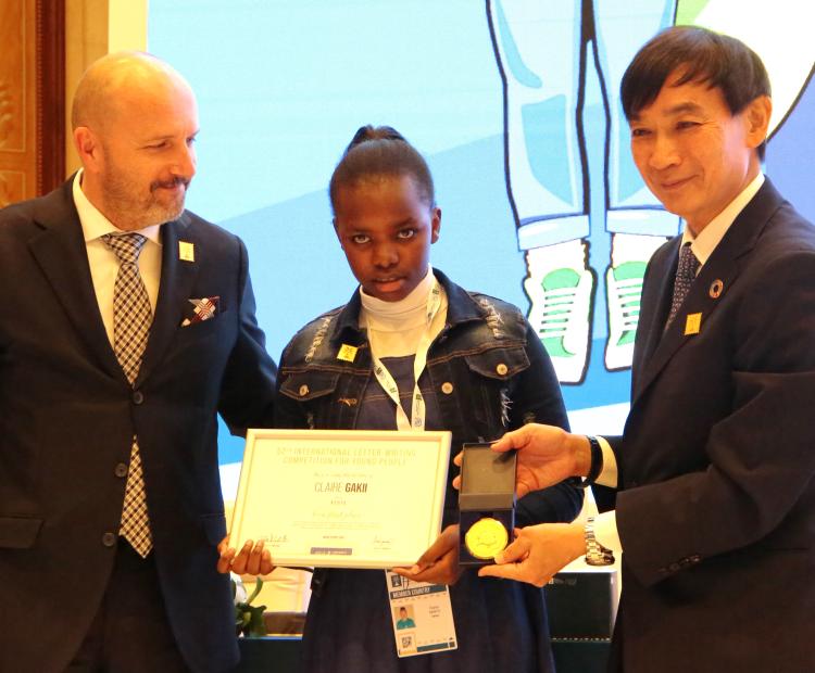 Kenya’s Claire Gakii (centre) receives the award of the winner of the International Letter Writing Competition for Young People from the Universal Postal Union Director General Mr. Masahiko Metoki (right) and his deputy Osvald Marjan in Riyadh, Saudi Arabia. She beat about 1.7 million others to clinch the coveted prize.